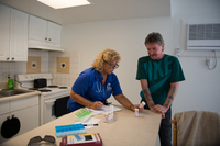 Nancy of the HOPE team works with Thomas on his medicine.